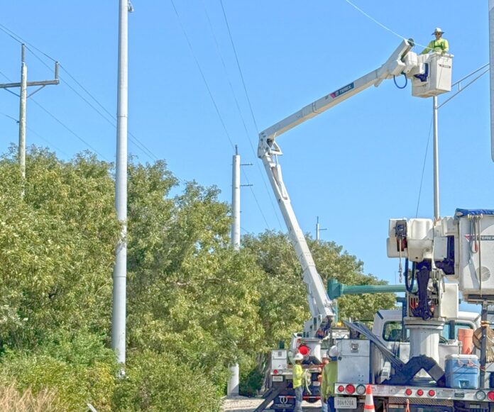 a couple of men working on a utility truck