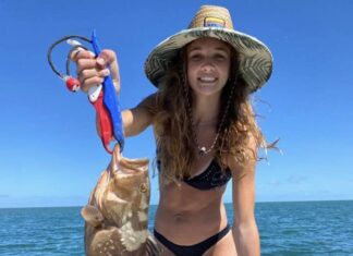 a woman in a bikini holding a fish