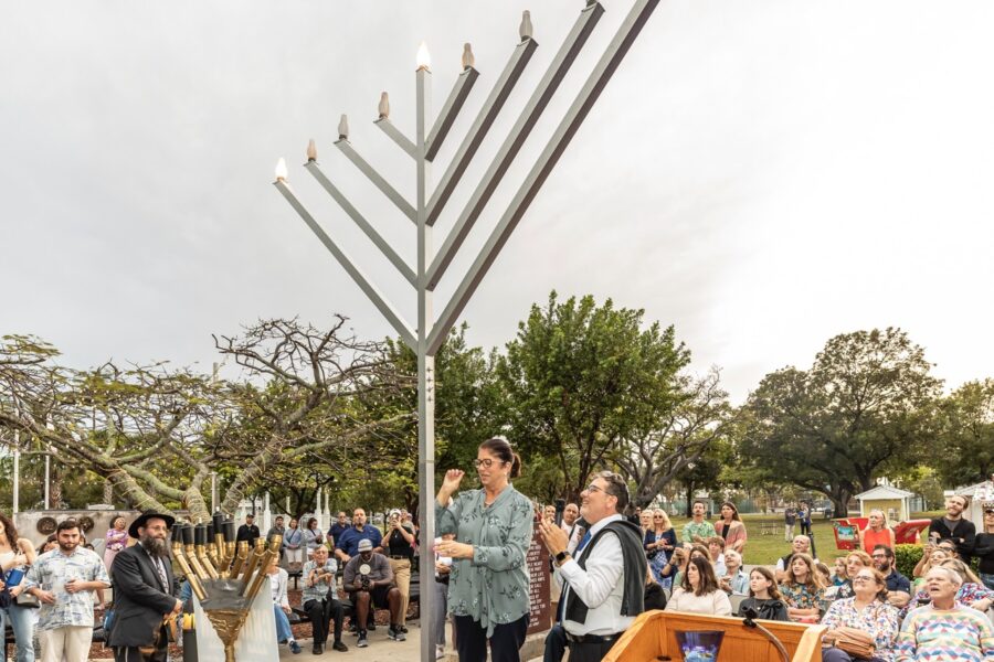 a group of people standing around a menorah