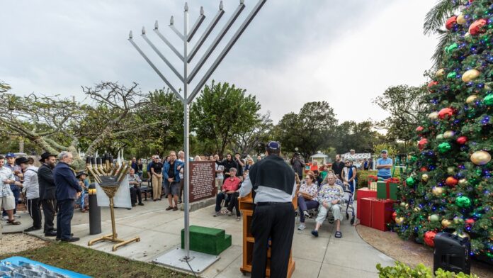 a group of people standing around a christmas tree