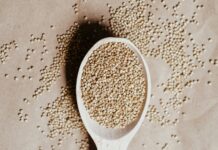 a wooden spoon filled with seeds on top of a table