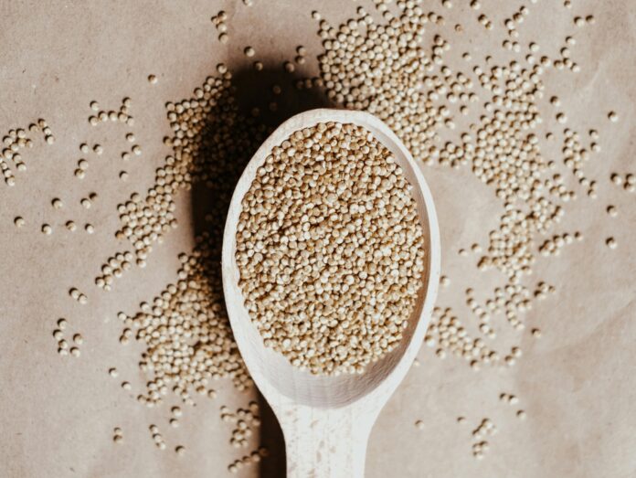 a wooden spoon filled with seeds on top of a table