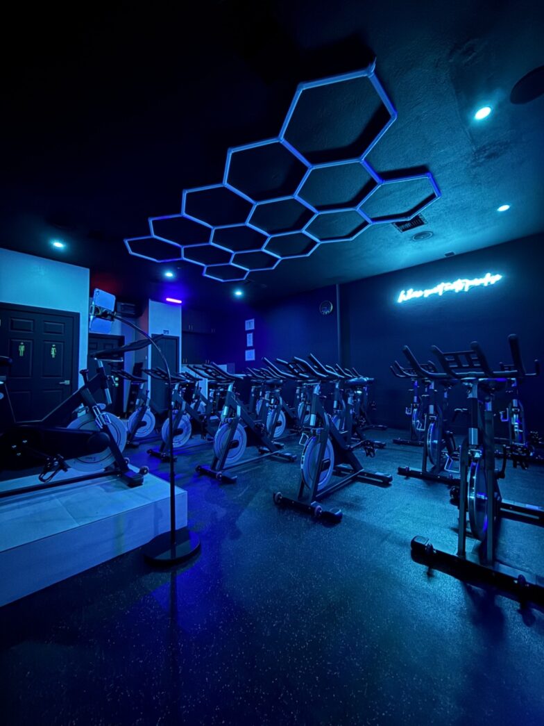 a gym filled with machines and blue lighting