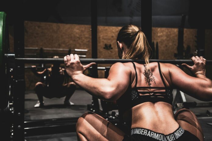 a woman squatting on a bench in a gym