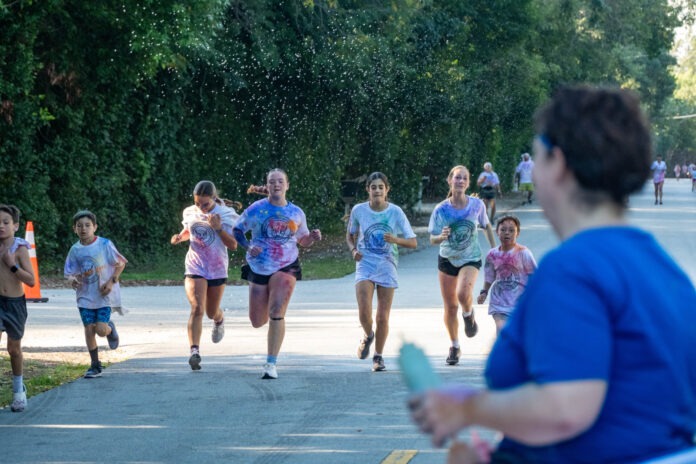 a group of people running down a street