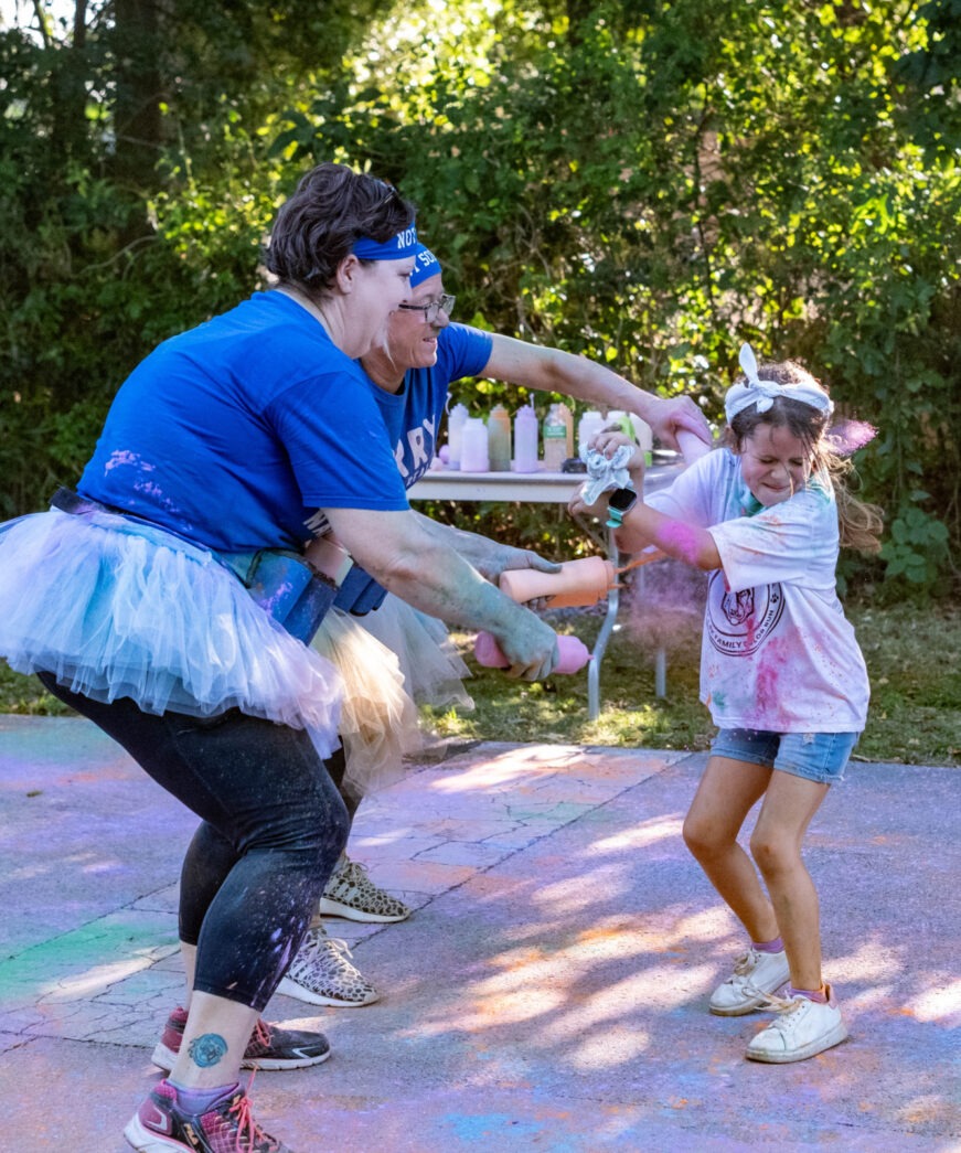 a woman and a little girl playing with a frisbee