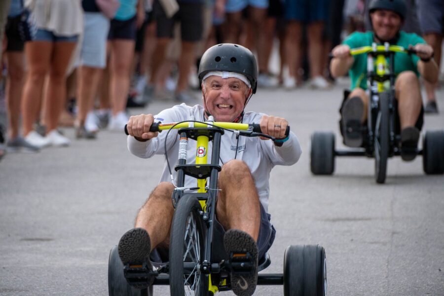 a group of people riding tricycles down a street