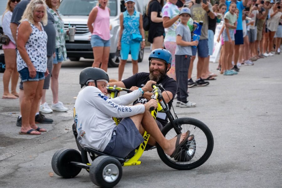 a group of people watching a man on a motorized bike