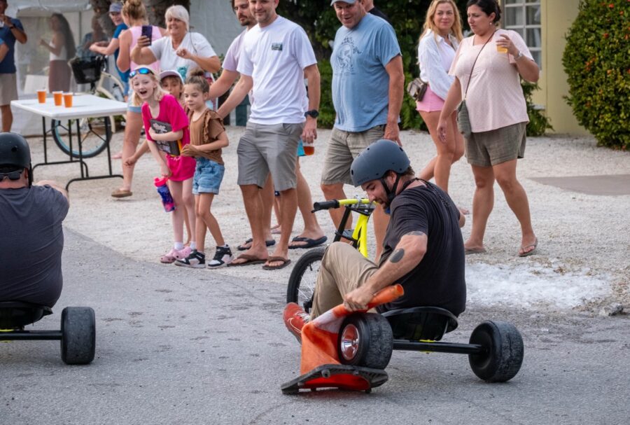 a group of people standing and sitting around a man in a wheel chair