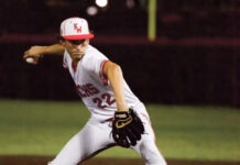 a baseball player pitching a ball on top of a field