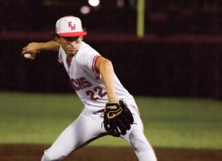 a baseball player pitching a ball on top of a field