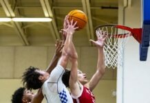 a group of young men playing a game of basketball