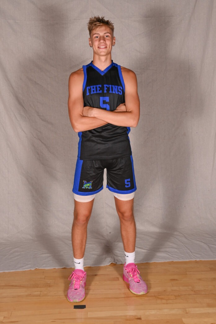 a man in a blue and black basketball uniform posing for a picture