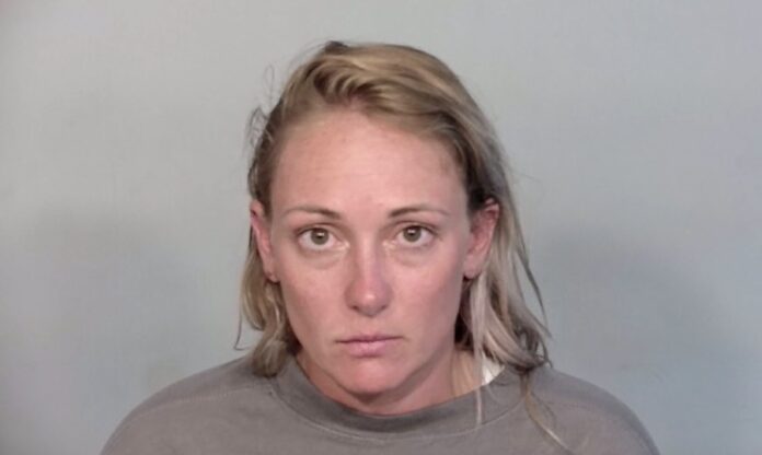 Screenshot a woman in a gray shirt is looking at the camera