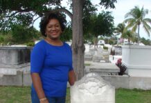 a woman standing in front of a grave