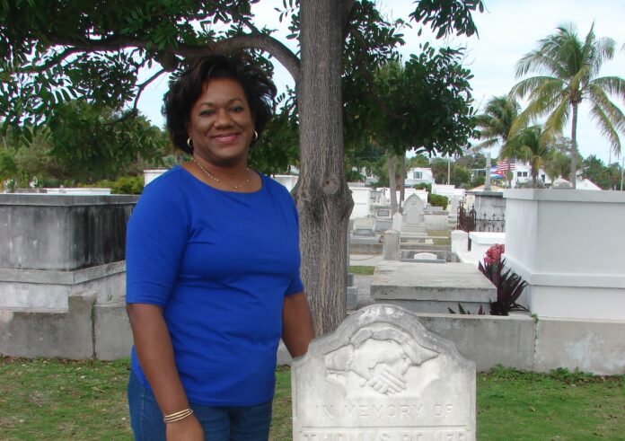 a woman standing in front of a grave