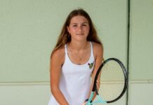 a girl in a white dress holding a tennis racket