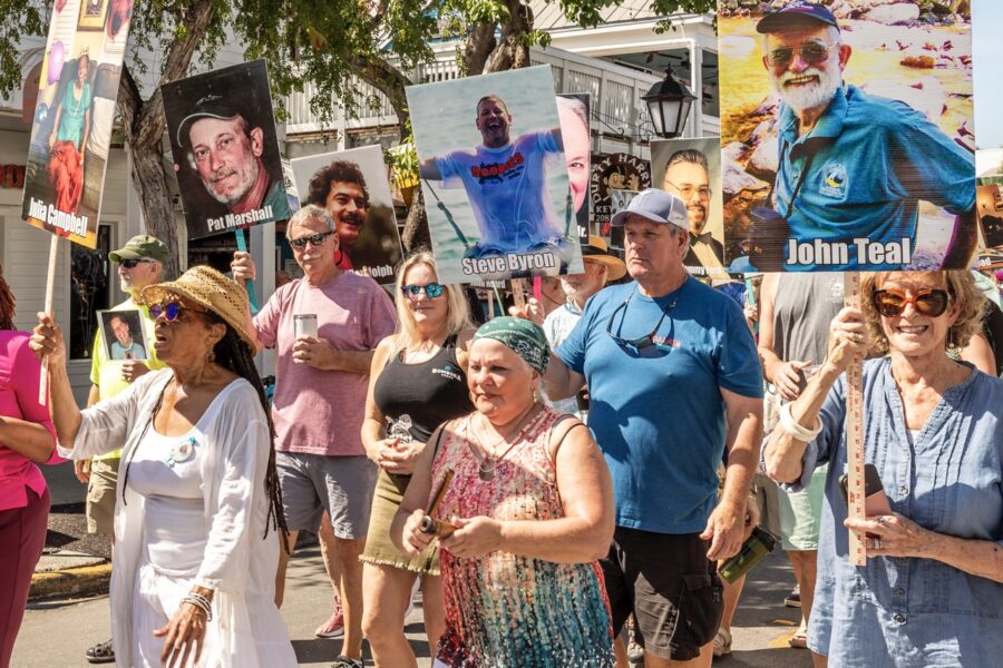 a group of people standing on a street holding signs