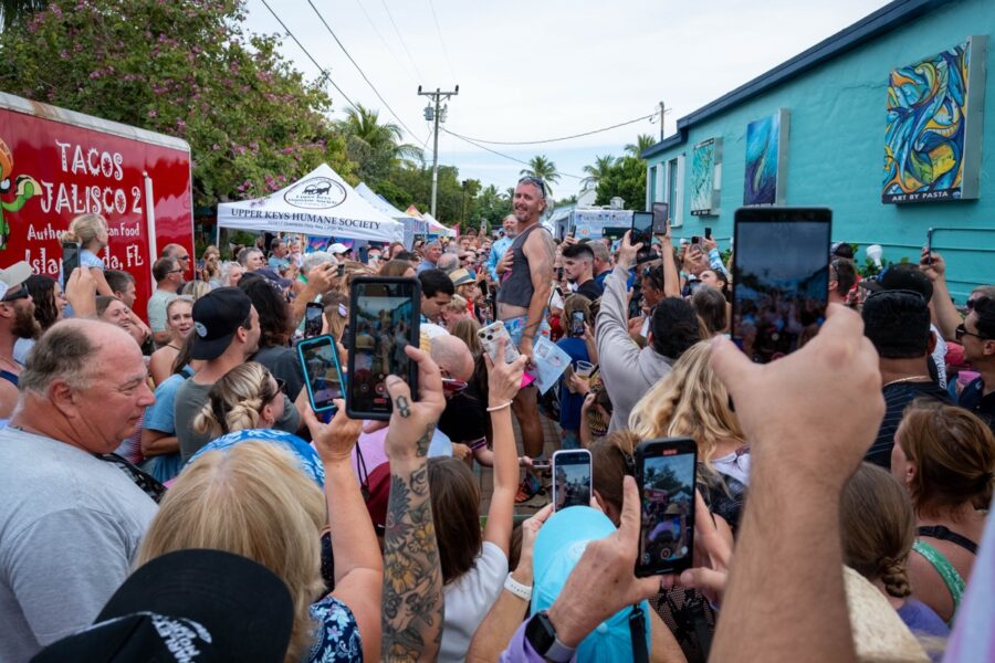 a crowd of people standing around each other