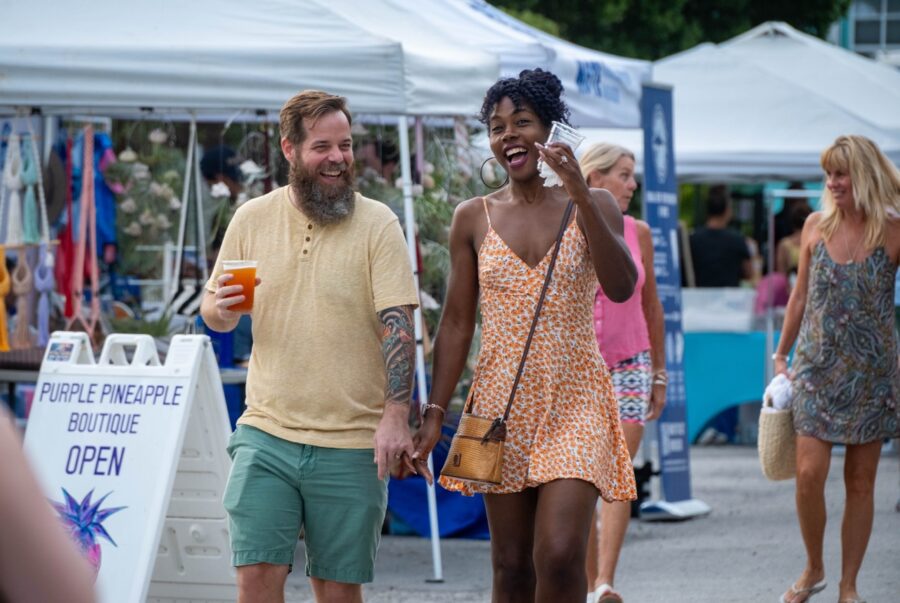 a man and woman walking down a street talking on a cell phone