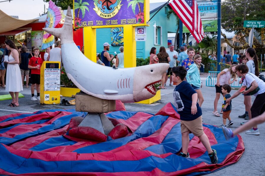 a group of people standing around a giant inflatable shark