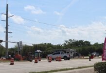 a street with construction cones and a sign on the side of the road