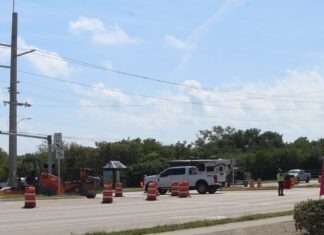 a street with construction cones and a sign on the side of the road