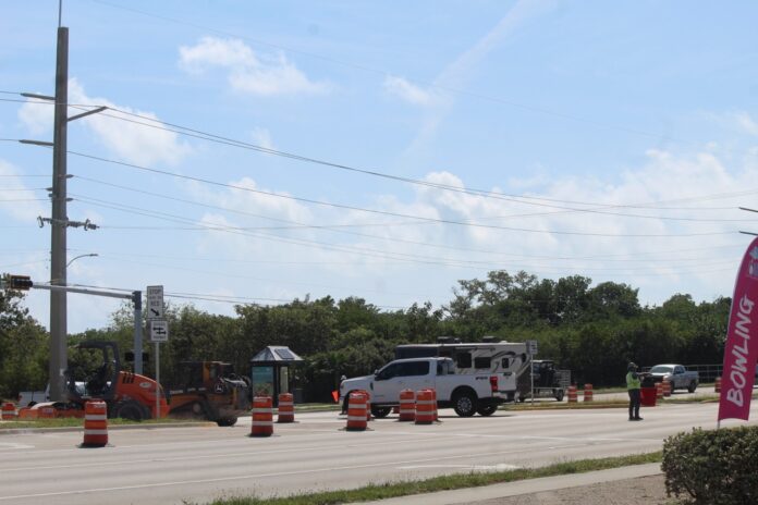 a street with construction cones and a sign on the side of the road