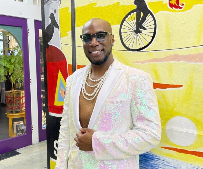 Floyd Vertical Inside Best a man in a white suit standing in front of a painting