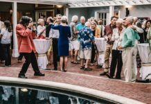 a group of people standing around a pool