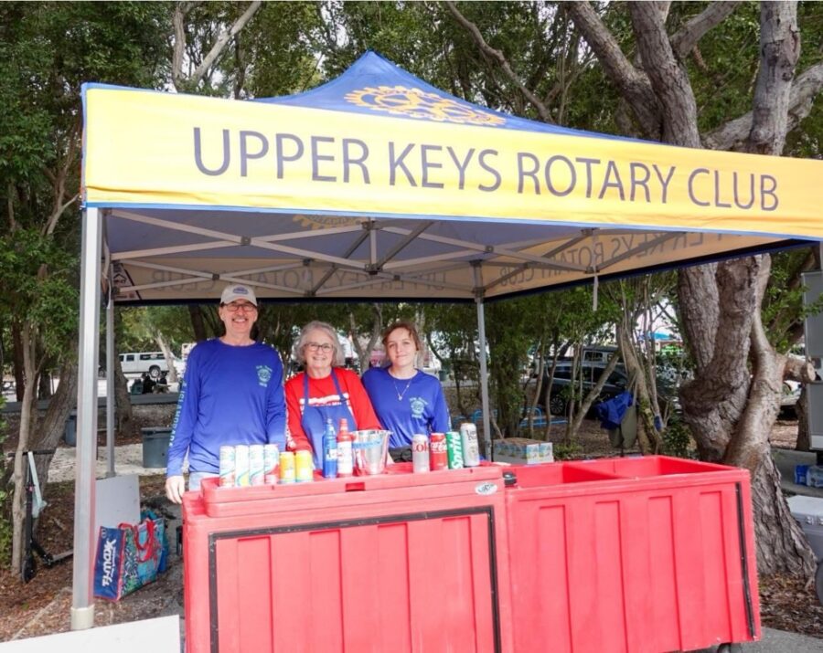 a group of people standing under a blue and yellow tent