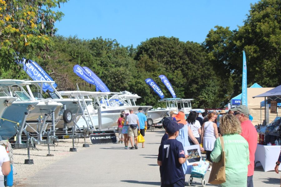 a group of people standing next to a row of boats