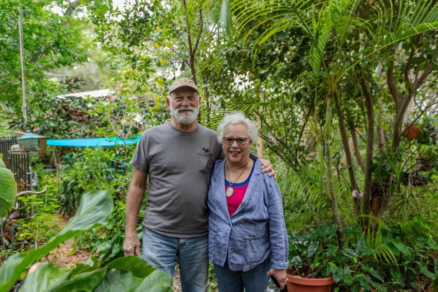 a man and a woman standing next to each other in a garden