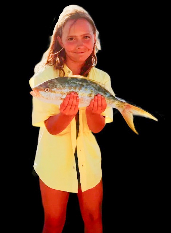 a woman in yellow is holding a fish