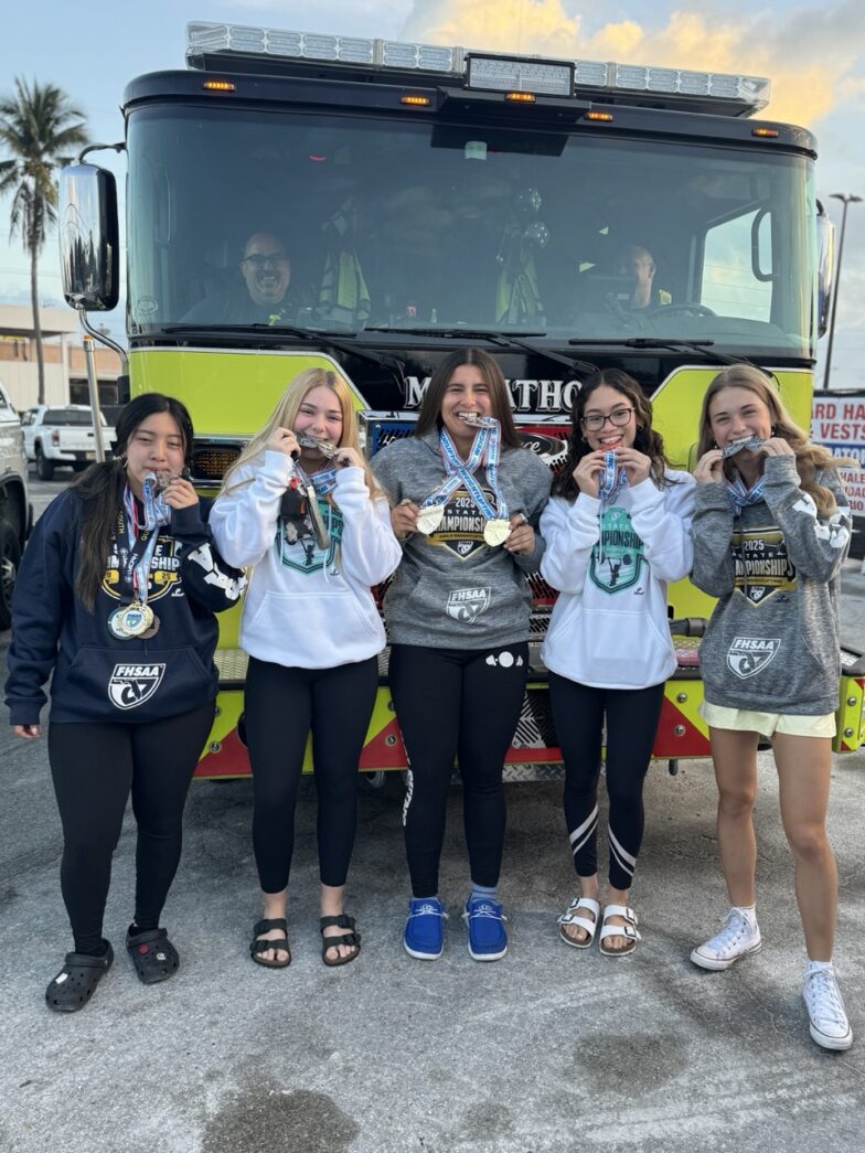 a group of girls standing in front of a fire truck