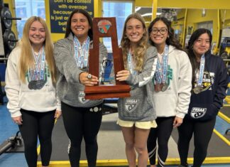 a group of girls standing next to each other holding a trophy