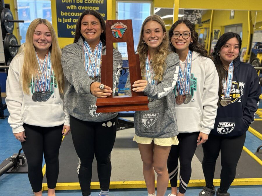 a group of girls standing next to each other holding a trophy