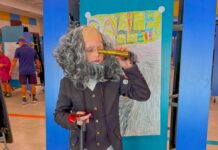 a child dressed in a wig and holding a wine bottle