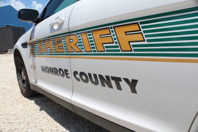 a sheriff car parked in a gravel lot