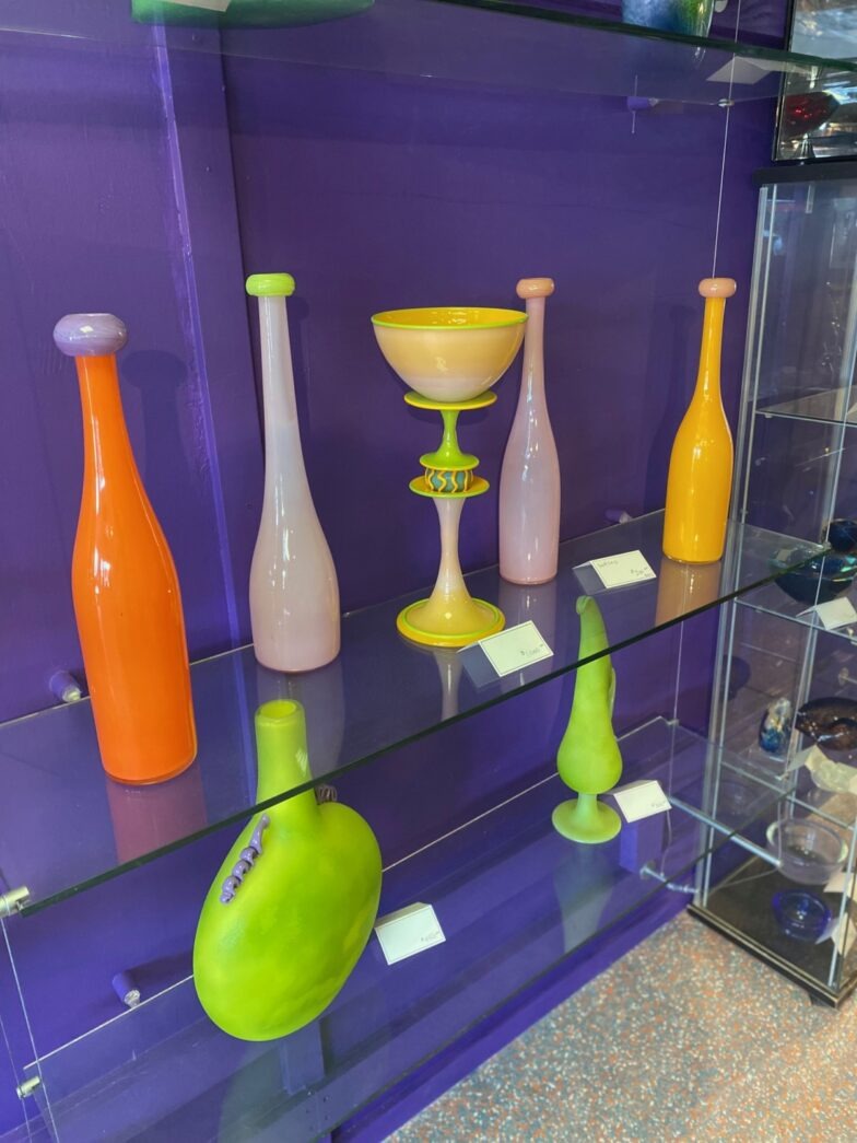 a display case filled with different colored vases