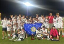 a group of young men standing on top of a soccer field