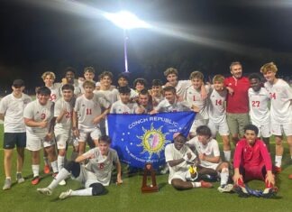 a group of young men standing on top of a soccer field