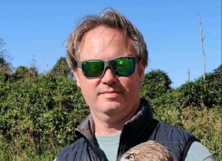 a man holding a bird of prey in his hands