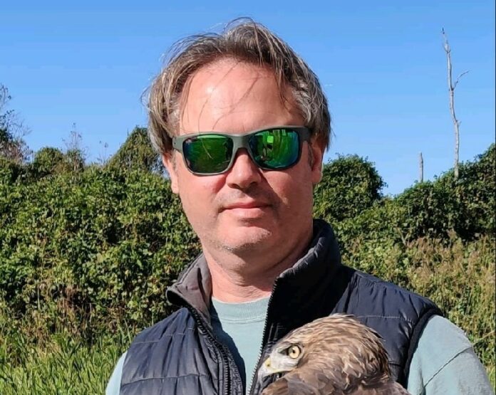 a man holding a bird of prey in his hands