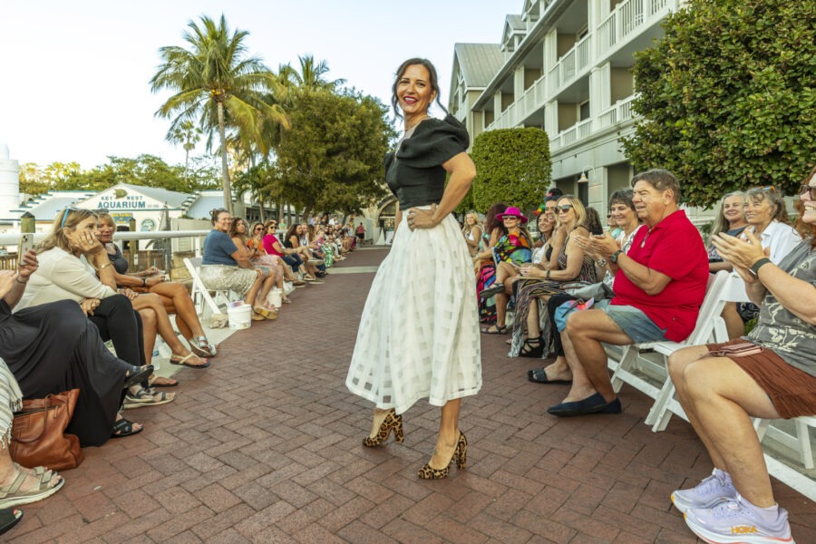 a woman is walking down the runway at a fashion show