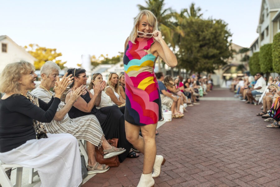 a woman in a colorful dress walking down a street