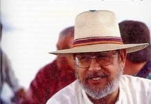 a man wearing a hat and glasses sitting down