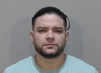 a mug shot of a man in a light blue shirt