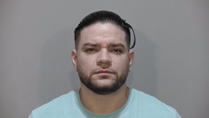 a mug shot of a man in a light blue shirt