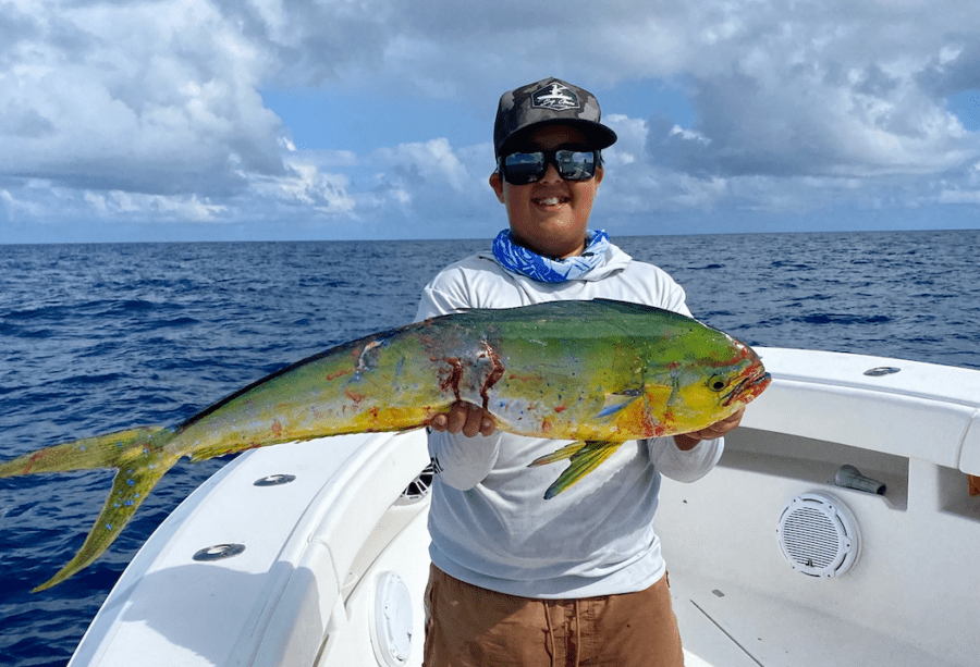 a man on a boat holding a fish